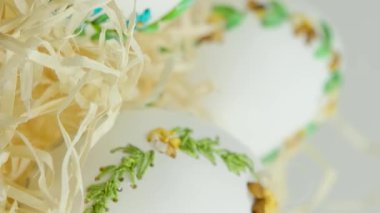 Easter three beautiful embroidered eggs with eggshell ribbons in nest with wrapping paper white background space for text congratulations meeting with family decoration home decoration gift delivery