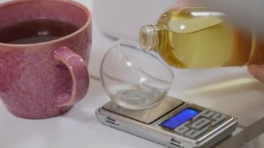 Kadın evde mum yapıyor, kadın ellerini kapatıyor tavadan silikon kalıba sarı sıvı balmumu döküyor. Yüksek kalitede kesilmiş vetil mum aromalı mum yapar.