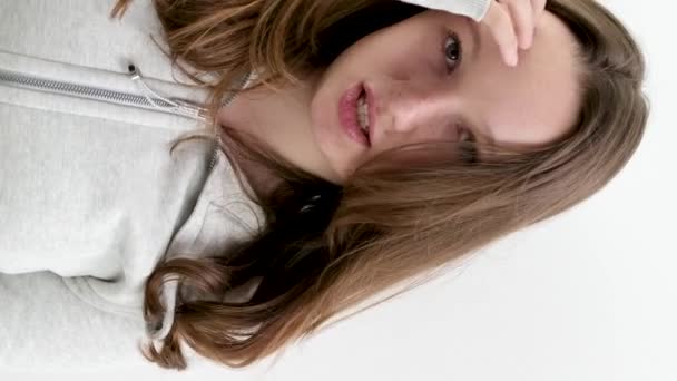 Ein Junges Mädchen Glättet Ihre Haare Steht Auf Weißem Hintergrund — Stockvideo