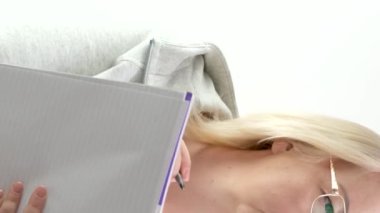 Bir gazeteci durumu gözlük takarak anlatıyor, not defterli orta yaşlı bir kadın dikkatlice çerçeveli sarı saçlara bakıyor. Parmağını kaldırdı.