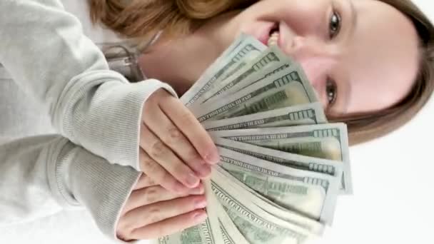 青少年时代的巨大快乐 第一笔钱赚了很多钱 一捆100美元的钞票 一个女孩在画框里展示钱 笑着张开她的嘴 充满喜悦 一份好礼物 — 图库视频影像