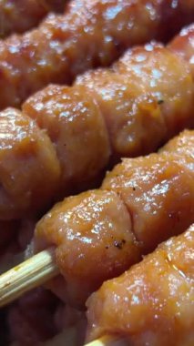 Domuz eti şişi yanıyor, koyun eti barbeküsü yakın plan. Kebap için kızarmış et. Izgara et, tavuk, kuzu barbekü. Izgarada kebap. Geleneksel yiyeceklerle Çin sokak marketi. 