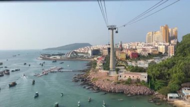 Phu Quoc Adası 'nın güneyinde gün batımında ufuk çizgisi üzerinde açık gökyüzü olan bir teleferik. Denizdeki gemiler