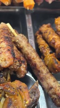 Yerel Asya sokak yemekleri. Phuket Eski Kasabası 'ndaki Gece Pazarı' nda Ateşli Bbq Grill 'de Aşçı Tavuk Satay. Yüksek Kaliteli Sinematik 4K Ağır çekim Tayland Mutfağı Görüntüsü. Tayland. Yüksek kalite