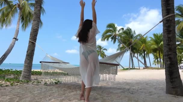 一位身穿白色长袍的年轻女子身着黑色泳衣跳舞 她躺在那里 静静看着海上的手机移动网络 Phu Quoc越南美丽的海滩 — 图库视频影像