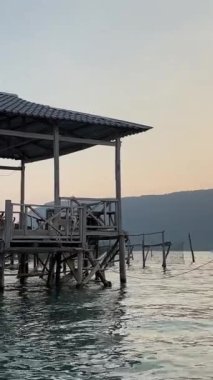 Hint Okyanusu 'ndaki balıkçı teknesindeki balıkçı evi Vietnam Pu Quoc adasında balık çiftliği yetiştiriyor. Sudaki restoran balık yakalar ağlar, ahşap evler bulutsuz gökyüzü ve sakin su
