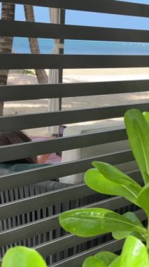 Şık lüks plaj. Beyaz pareo siyah mayo giymiş genç bir kız dans ediyor. Dinlenmiş içecekler içiyor. Phu Quoc 'un Vietnam muhteşem plajları