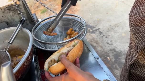 過剰に調理された悪い食べ物は ベトナムの健康と危険な安いストリートフードに悪いです ベトナムの女性は揚げるために異なる成分で束を詰める — ストック動画