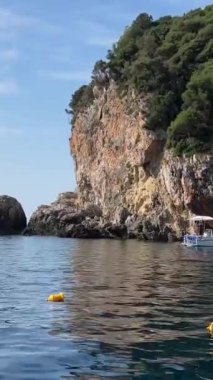 Korfu adası yakınlarındaki tekne turu temiz su dağlarının derinliklerinde doğal bahar mevsiminde kayıkçıları geçiyor. turistler ve gezginler