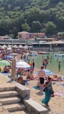 İyon Denizi 'ndeki Korfu adasındaki en ünlü Avrupa plajı. Tatilciler, aktif spor yüzme sporları, şemsiyeler, 09.09.2023 Yunanistan.