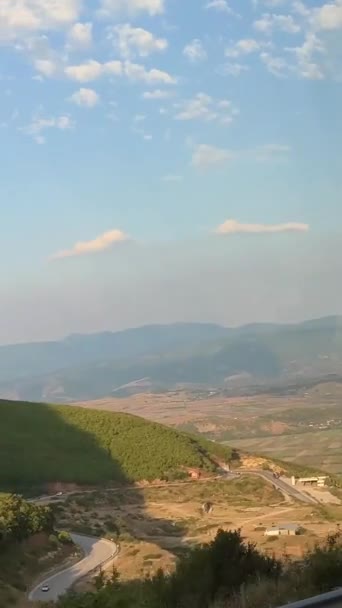 从阿尔巴尼亚山区的窗口望去 经过的车辆在道路上轻盈多云的天空夏天 路线旅行 — 图库视频影像