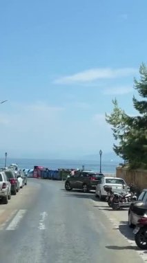 Korfu adası arabaları şehir turistleri arasında tanınmayan insanların yanından geçiyor. Yunanistan