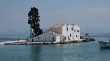 Yunanistan 'ın Korfu adası Vlacherna Manastırı üzerinden kalkan ve karaya inen sudaki manastır. 