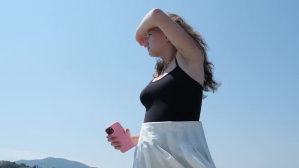 Genç Bir Kız Telefon Kullanıyor Gökyüzüne Karşı Uçan Bir Uçağın — Stok video