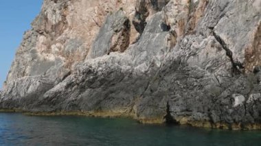 Korfu adası yakınlarındaki tekne turu temiz su dağlarının derinliklerinde doğal bahar mevsiminde kayıkçıları geçiyor. Turistler ve gezginler Mağara Taşları Suyu