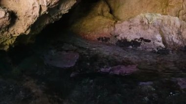 Korfu adası yakınlarındaki tekne turu temiz su dağlarının derinliklerinde doğal bahar mevsiminde kayıkçıları geçiyor. Turistler ve gezginler Mağara Taşları Suyu