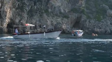 Korfu adası yakınlarındaki tekne turu temiz su dağlarının derinliklerinde doğal bahar mevsiminde kayıkçıları geçiyor. turistler ve gezginler