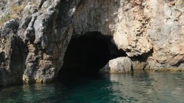 Korfu adası yakınlarındaki tekne turu temiz su dağlarının derinliklerinde doğal bahar mevsiminde kayıkçıları geçiyor. Turistler ve gezginler Mağara Taşları Suyu