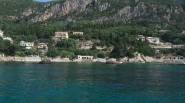 Korfu adası yakınlarındaki tekne turu temiz su dağlarının derinliklerinde doğal bahar mevsiminde kayıkçıları geçiyor. turistler ve gezginler