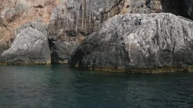 Korfu adası yakınlarındaki tekne turu temiz su dağlarının derinliklerinde doğal bahar mevsiminde kayıkçıları geçiyor. Turistler ve gezginler Mağara Taşları Suyu