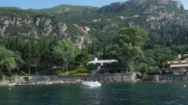 Korfu adası yakınlarındaki tekne turu temiz su dağlarının derinliklerinde doğal bahar mevsiminde kayıkçıları geçiyor. turistler ve gezginler