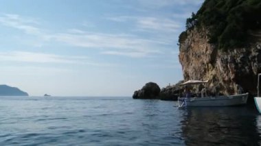 Korfu adası yakınlarındaki tekne turu temiz su dağlarının derinliklerinde doğal bahar mevsiminde kayıkçıları geçiyor. Turistler ve gezginler Mağara Taşları Suyu