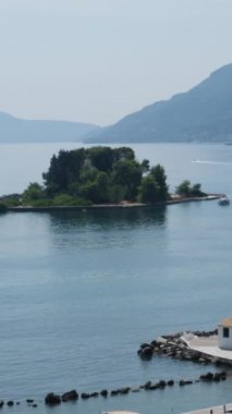 Yunanistan 'ın Korfu adası Vlacherna Manastırı üzerinden kalkan ve karaya inen sudaki manastır. 