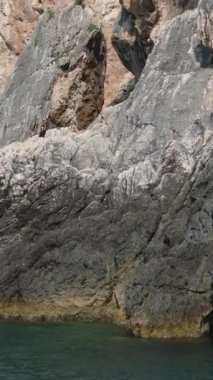 Korfu adası yakınlarındaki tekne turu temiz su dağlarının derinliklerinde doğal bahar mevsiminde kayıkçıları geçiyor. Turistler ve gezginler Mağara Taşları Suyu