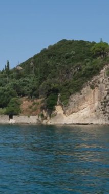 Korfu adası yakınlarındaki tekne turu temiz su dağlarının derinliklerinde doğal bahar mevsiminde kayıkçıları geçiyor. turistler ve gezginler