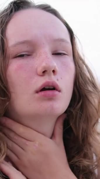 女の子は肌を燃やしました 赤い頬 濡れた髪 保険会社は 夏に海水泳夏休みで風邪を引く喉を抱えている重要なスロートガールです 湖の背景にある女性 — ストック動画