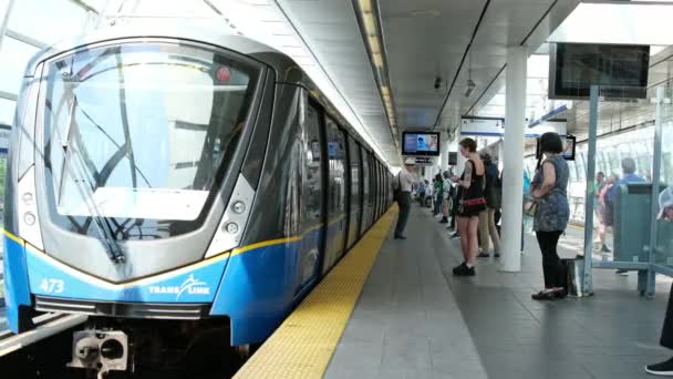 ブルーラインのスカイトレイン列車はウォーターフロントからキングスジョージ駅のウォーターフロントまで運行され デレイ スカイトレインの人々はプラットフォームで待機した カナダ バンクーバー 2024 — ストック動画