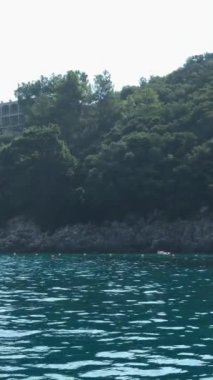 Korfu adası yakınlarındaki tekne turu temiz su dağlarının derinliklerinde doğal bahar mevsiminde kayıkçıları geçiyor. turistler ve gezginler