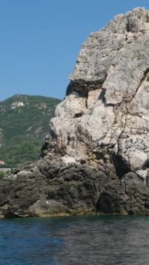 Korfu adası yakınlarındaki tekne turu temiz su dağlarının derinliklerinde doğal bahar mevsiminde kayıkçıları geçiyor. turistler ve gezginler