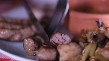 Bıçak ve çatalla lezzetli lula kebabı kes.