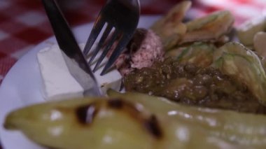 Tabakta, bir Arnavut Makedon Türk restoranında yemek için bıçak ve çatalla kesilmiş ızgara sebze ve Feta peyniri var.