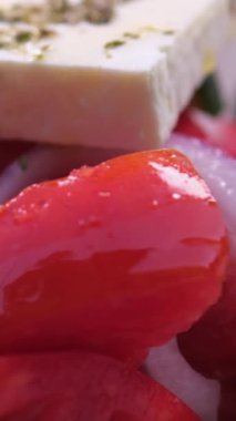 Marul yapraklı taze salata ve kaseye düşen domates. Sağlıklı besin maddeleriyle servis ediliyor. Yunan salatası, sebze, zeytin, peynir, sebze, zeytin, peynir.
