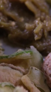 Makedonya 'daki bir restoranda, yemek kırmızı kare masa örtüsü üzerinde servis ediliyor. Izgara kabak, ızgara biber, domatesli salata peynirli çörek.