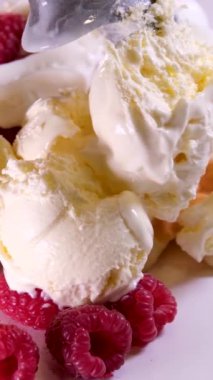 Sahilde yeni evlisini yiyen bir kızın yakın çekimi. Bir kadın kirazlı ve fıstıklı yoğurtlu dondurma yiyor. Bir kadının eli kaşıkla dondurma alır. Kremalı ve ahududulu waffle.