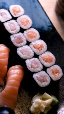 Japon bir aşçının ön çekimi suşi tabağı ile suşi barında çiğ balık hazırlar. Elleri yakın çekim. Yüksek kalite 4k görüntü