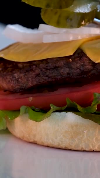 全景汉堡包与多汁油炸切片 新鲜生菜 薄片奶酪 洋葱和西红柿旁边的薯条和酱汁在一个杯子里 一步一步地做一个汉堡包 — 图库视频影像