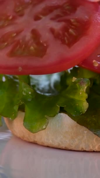 ジューシーなフライドカットレタス チーズの薄いスライス タマネギ トマトをガラスカップのフライドポテトの隣で調理したハンバーガーのパノラマショット ステップバイステップでハンバーガーを調理 — ストック動画