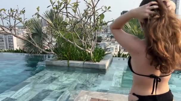 穿着泳衣的晒黑了的女游客沐浴在无尽的大海中 穿着比基尼的布鲁内特女士在豪华温泉度假胜地的游泳池里放松一下 享受阳光下的海景 — 图库视频影像
