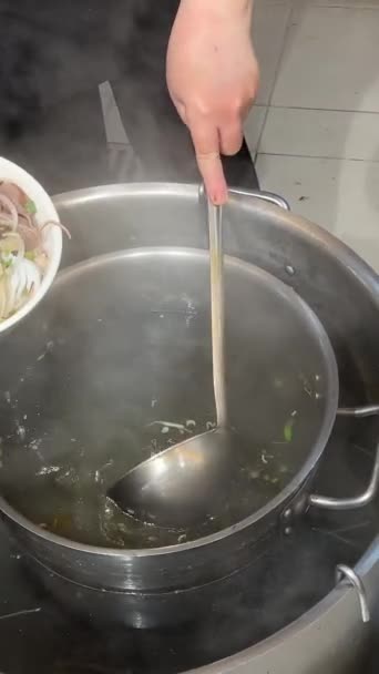 一张特写照片 是一碗热气腾腾的Pho 肉汤是浅褐色的 上面漂浮着薄薄的牛肉片 白洋葱和青葱 还有白色的筷子 高质量4K — 图库视频影像