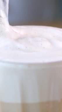 Kadın elleri açık hava restoranında metal pipetle kokteyl karıştırıyor. Güneşli tropikal kafede çikolatalı milkshake içen genç bir kadın. Masadaki kız buzlu kahve içiyor. 