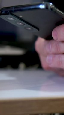 Erkek el kadar akıllı telefon tutarak kapatın. Pencere duran cep telefonu kullanan adam. Dokunmatik ekranda dokunarak. Siluet