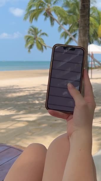 Молода Жінка Використовуючи Смартфон Гамаку Лежить Між Пальмами Тропічному Кліматі — стокове відео