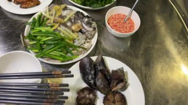Masada kızarmış tavuk kanadı sosu. Asya mutfağı kabuklu deniz ürünleri pirinç bol yeşillik ve et.