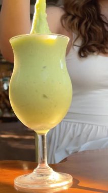Genç kadın parkta iyi eğlenceler ve yeşil smoothies iç