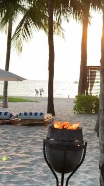Fukuoka Phu Quoc Sonasea plajındaki kumsalda meşale. Palmiye ağaçları Hint Okyanusu 'nda gün batımında otellerin yakınında tatil yaparlar. Seyahat acentesi doğanın güzelliği 