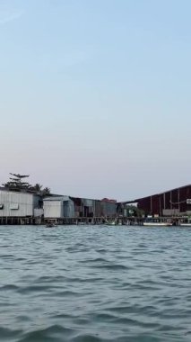 Hint Okyanusu 'ndaki balıkçı teknesindeki balıkçı evi Vietnam Pu Quoc adasında balık çiftliği yetiştiriyor. Sudaki restoran balık yakalar ağlar, ahşap evler bulutsuz gökyüzü ve sakin su